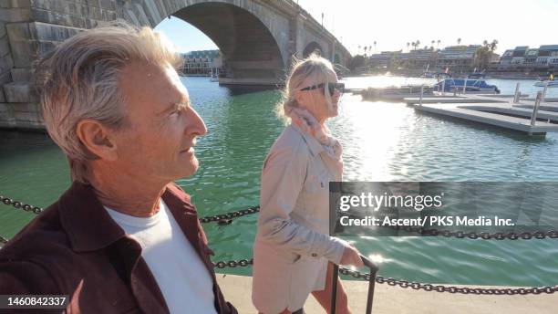 mature couple walk under arched bridge - london bridge arizona stockfoto's en -beelden