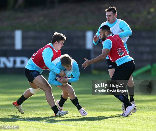 Fin Smith is held by Guy Porter and Joe Marchant during the England training session held at Pennyhill Park on January 30, 2023 in Bagshot, England.