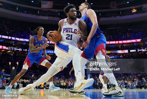 Joel Embiid of the Philadelphia 76ers drives to the basket against Nikola Jokic of the Denver Nuggets at the Wells Fargo Center on January 28, 2023...