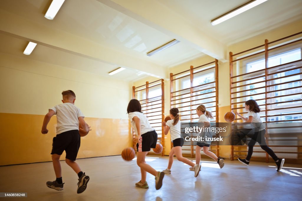 Schulkinder üben das Dribbling während des Sportunterrichts