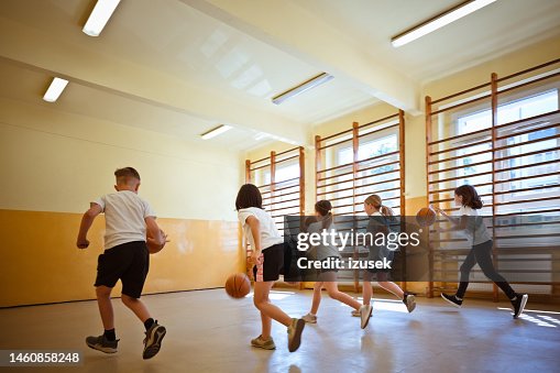 Schulkinder üben das Dribbling während des Sportunterrichts Schulkinder üben das Dribbling während des Sportunterrichts