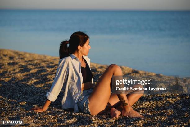 close up view portrait of dreaming and relaxing young woman sitting on the seaside. cheerful mood. front view. power of people. healthy wellness lifestyle. spiritual health. personal fulfillment. - ladies day stock pictures, royalty-free photos & images