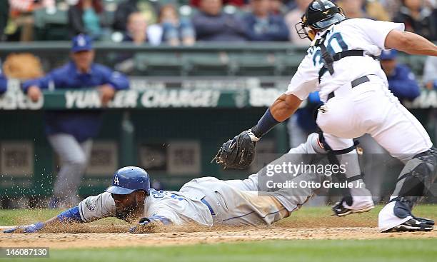 Tony Gwynn Jr. #10 of the Los Angeles Dodgers scores on a fielders choice by Elian Herrera in the ninth inning against catcher Miguel Olivo of the...