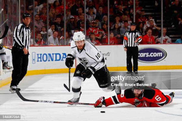 Mike Richards of the Los Angeles Kings goes for a loose puck as Andy Greene of the New Jersey Devils hits the ice during Game Five of the 2012 NHL...