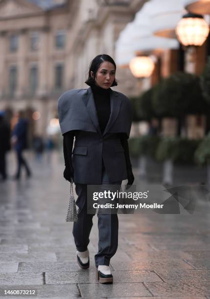 Farah Assaad seen wearing Ezzat official grey suit, white / black Ezzat official boots, smallsilver Ezzat official bag during Paris Fashion Week on...