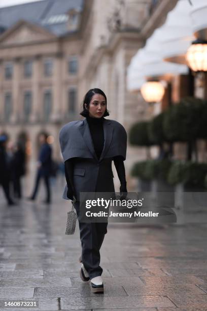 Farah Assaad seen wearing Ezzat official grey suit, white / black Ezzat official boots, smallsilver Ezzat official bag during Paris Fashion Week on...