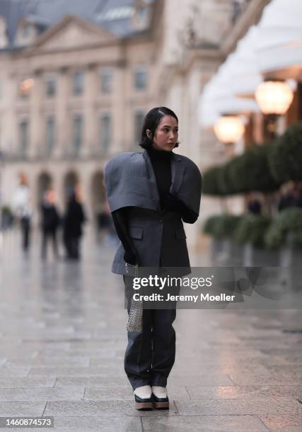 Farah Assaad seen wearing Ezzat official grey suit, white / black Ezzat official boots, small silver Ezzat official bag during Paris Fashion Week on...