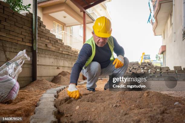 construction worker paving slabs, brick slab construction. - paving contractor stock pictures, royalty-free photos & images
