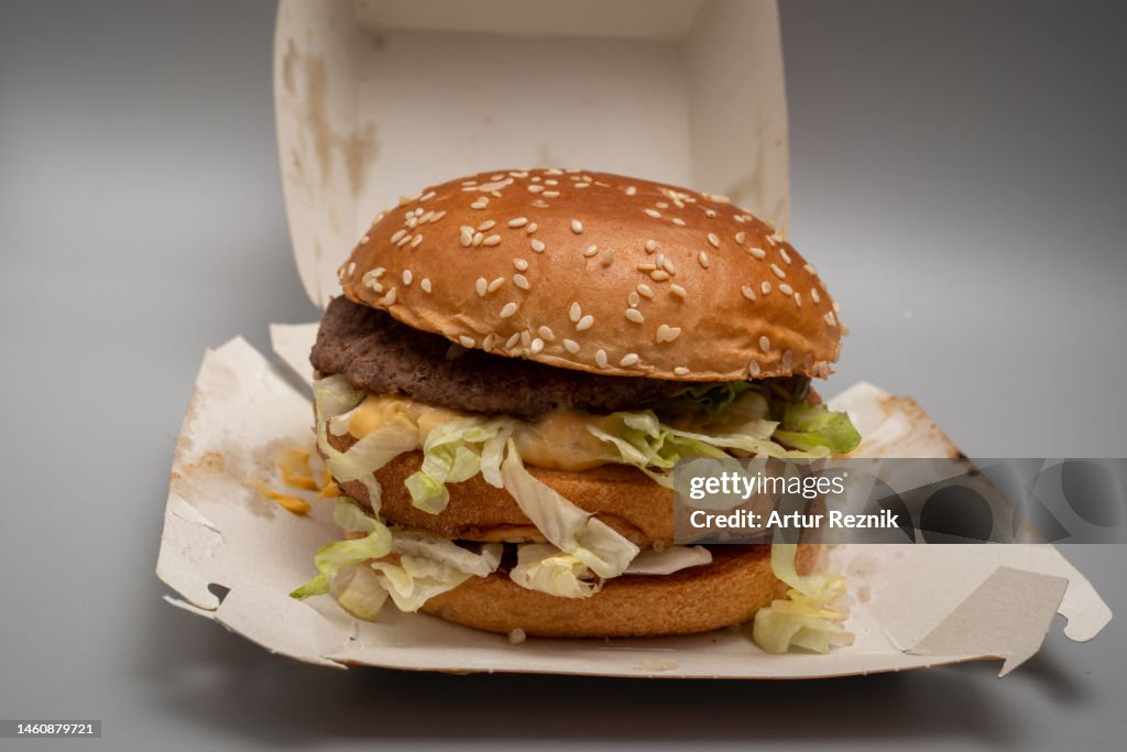 マクドナルドレストランから持ち帰られたずさんな組み立てまたは調理されたビッグマックバーガーの接写