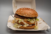 closeup of sloppy assembled or cooked Bigmac burger taken away from McDonalds restaurant