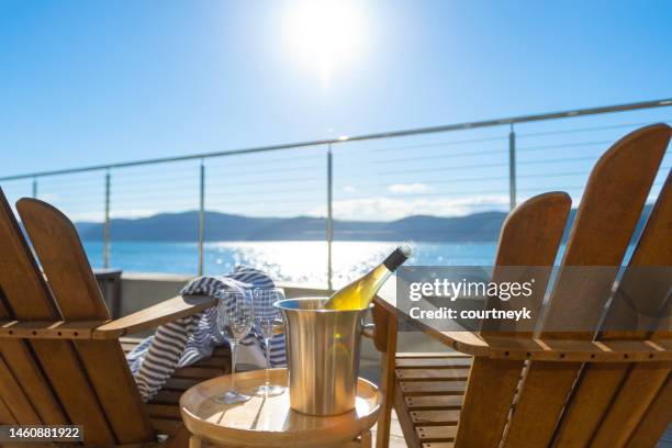 two deck chairs on a waterfront balcony. - beach deck stock pictures, royalty-free photos & images