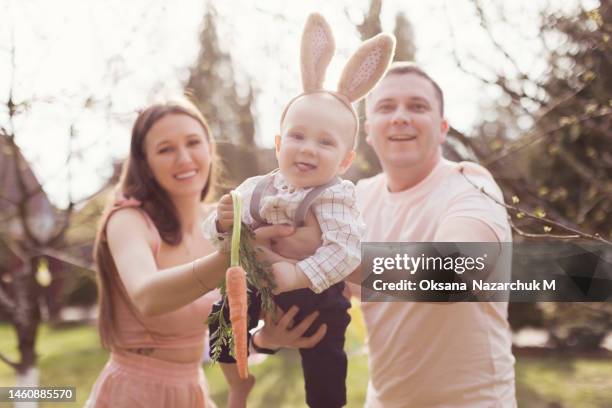 happy caucasian family at spring garden - happy easter mom stockfoto's en -beelden