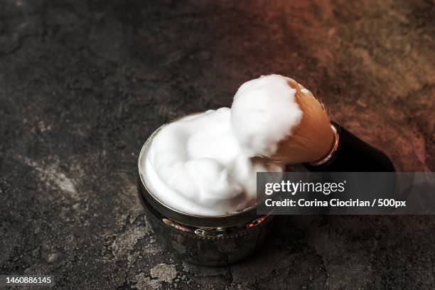 shaving brush and cream on dark plaster background - shaving brush fotografías e imágenes de stock