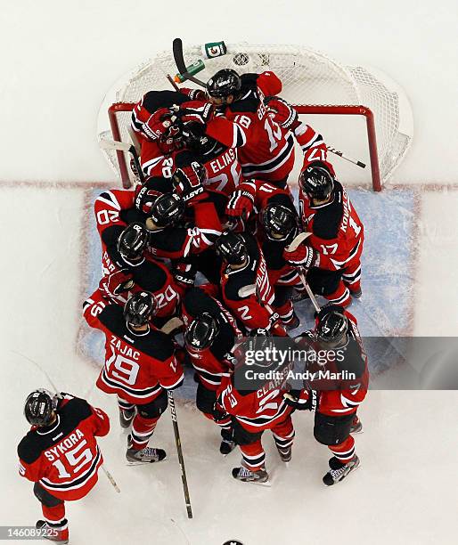 Winning goaltender Martin Brodeur of the New Jersey Devils is congratulated by his teammates after defeating the Los Angeles Kings in Game Five of...