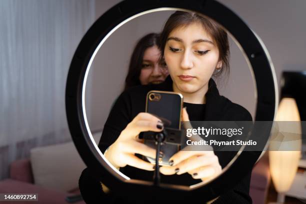 retrato de una adolescente filmando videos en casa y bailando a la cámara en la luz del anillo, concepto de joven blogger, espacio de copia - chica bailando en pijama fotografías e imágenes de stock