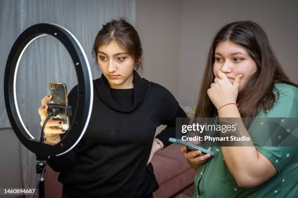 portrait of teenage girl filming videos at home and dancing to camera set on ring light, young blogger concept, copy space - cute arab girls stockfoto's en -beelden