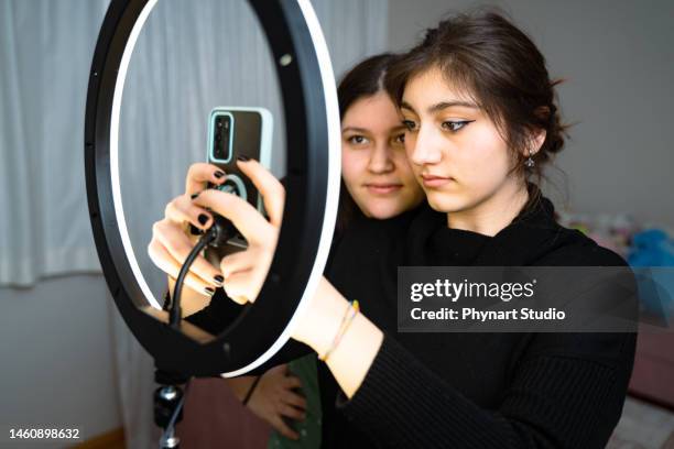 portrait of teenage girl filming videos at home and dancing to camera set on ring light, young blogger concept, copy space - teen doing filming imagens e fotografias de stock