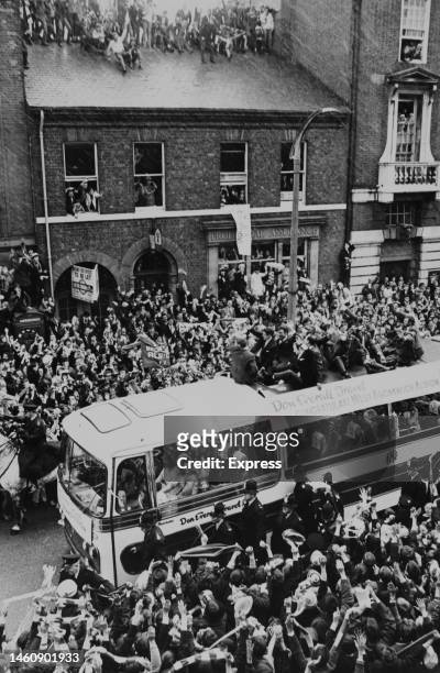 Crowds of West Bromwich Albion fans greet the coach carrying their team after they beat Everton in the 1968 FA Cup final, fans can be seen in the...