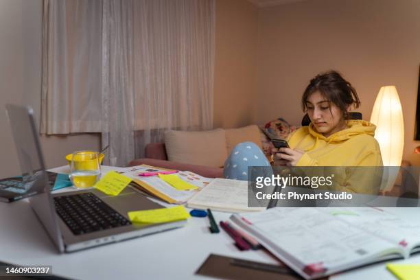 mädchen arbeitet an hausaufgaben für die schule. junge frau liest forschungsartikel über ihr hobby. bildungskonzept - homegirl stock-fotos und bilder