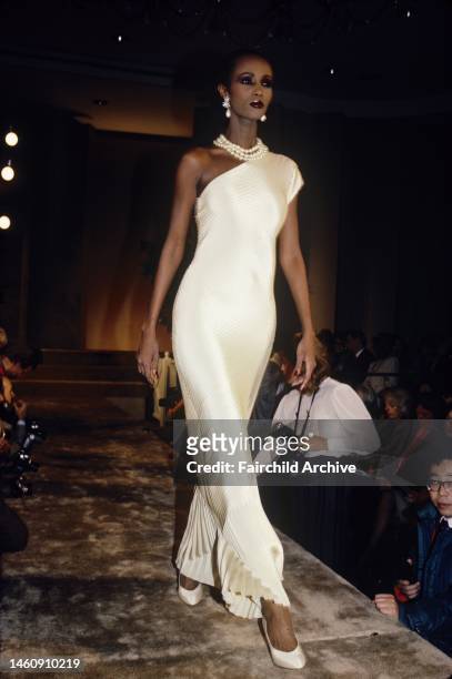 Iman models a one-shoulder white dress with pearl necklace in the Bill Blass Spring 1986 RTW show