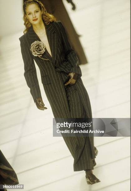 Menswear inspired pinstriped pantsuit with long coat accented with cloth flower from Emporio Armani's Fall 1995 show