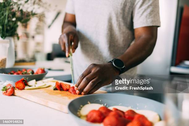 an unrecognizable man preparing healthy breakfast while standing in the kitchen - cooking breakfast stock pictures, royalty-free photos & images