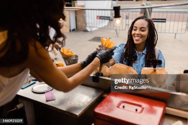 portrait of a happy girl choosing fast food on the street - prepared potato stock pictures, royalty-free photos & images