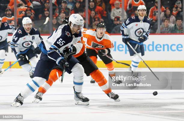 Mark Scheifele of the Winnipeg Jets skates after the puck against Scott Laughton and Travis Konecny of the Philadelphia Flyers at the Wells Fargo...