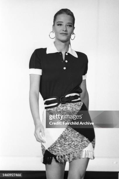 Models walk down runway for Perry Ellis Portfolio, Spring 1992 RTW. Here, model is wearing a navy cotton polo with a white and navy cotton buffalo...