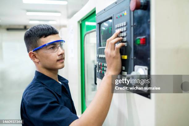 technician controlling cnc machine.man input program by keyboard. - manual worker milling machine operator photos et images de collection