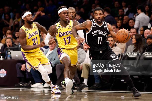 Kyrie Irving of the Brooklyn Nets dribbles as Patrick Beverley and Dennis Schroder of the Los Angeles Lakers defend during the second half at...