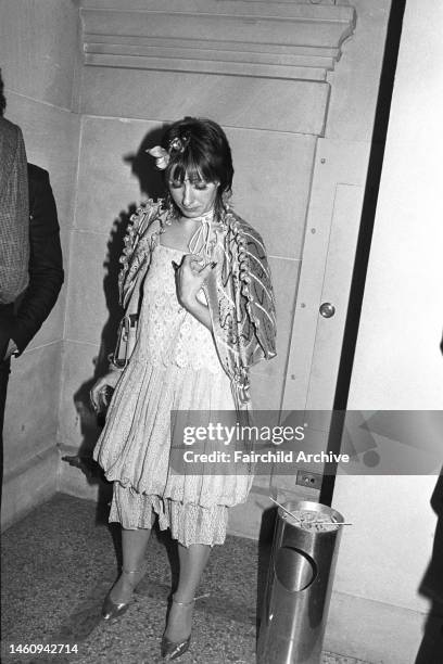 Fashion and costume designer Zandra Rhodes wearing a tiered lace dress with a cape and floral headpiece at Richard Avedon's photography opening at...