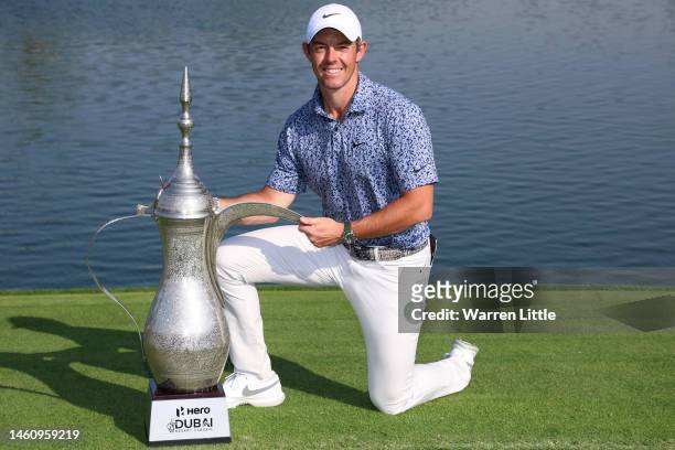 Rory McIlroy of Northern Ireland poses with the trophy on the 18th green, following victory in the final round of the Hero Dubai Desert Classic at...