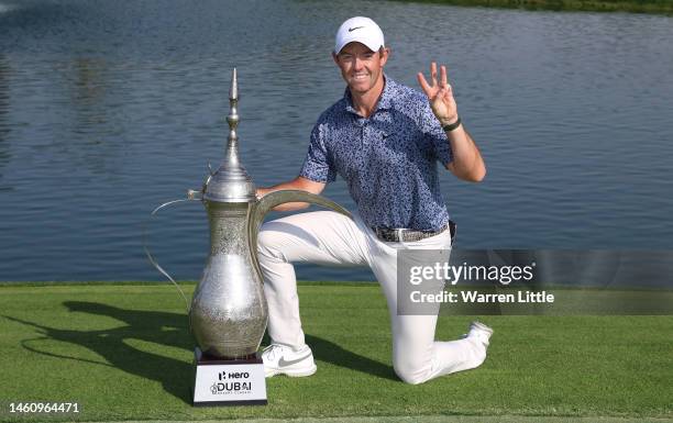 Rory McIlroy of Northern Ireland poses with the trophy on the 18th green following victory in the final round of the Hero Dubai Desert Classic at...