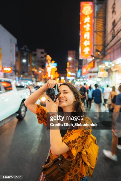 frau fotografiert mit kamera in chinatown, bangkok - asien metropole nachtleben stock-fotos und bilder