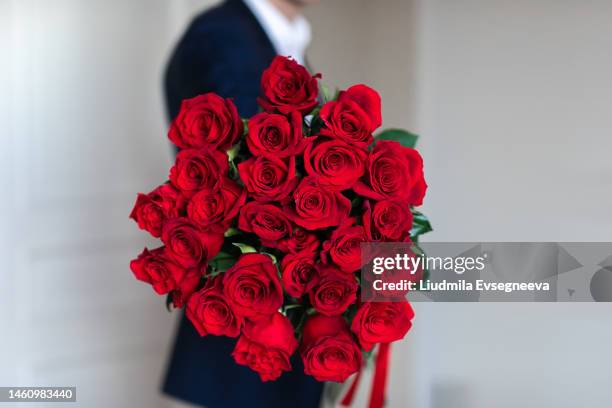 man with red roses bouquet - man holding flower bouquet stock pictures, royalty-free photos & images