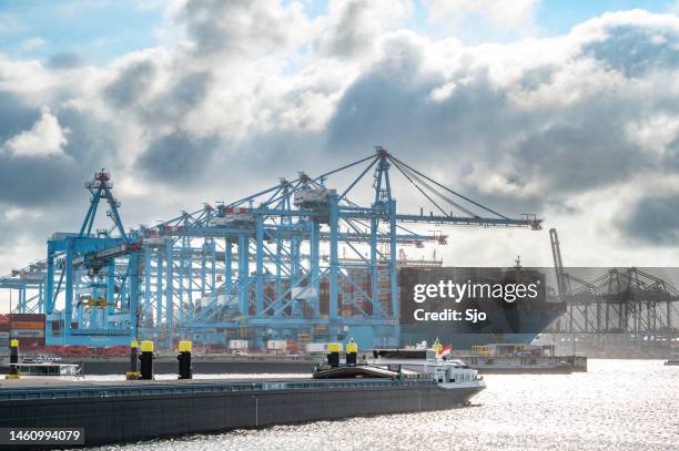 shipping container terminal in the port of rotterdam with a barge in the foreground - barge stock pictures, royalty-free photos & images