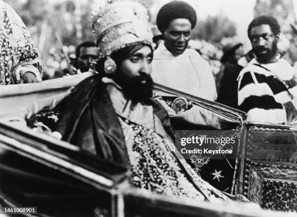 Haile Selassie travelling in an open carriage after his coronation, he wears ornate clothing and crown, Addis Ababa, Ethiopia, November 1930.