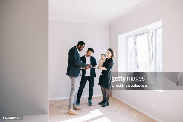 young family signing contract with real estate agent - real people family portraits stockfoto's en -beelden