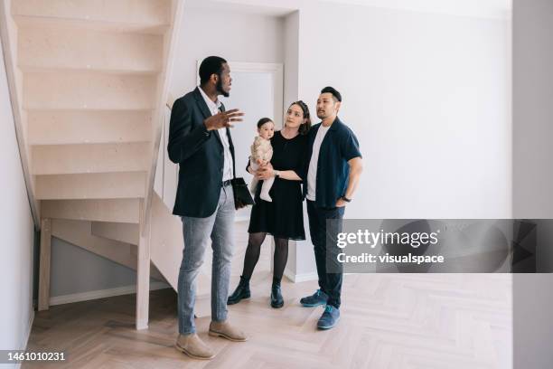 real estate agent giving home tour for potential clients. - real estate showing stock pictures, royalty-free photos & images
