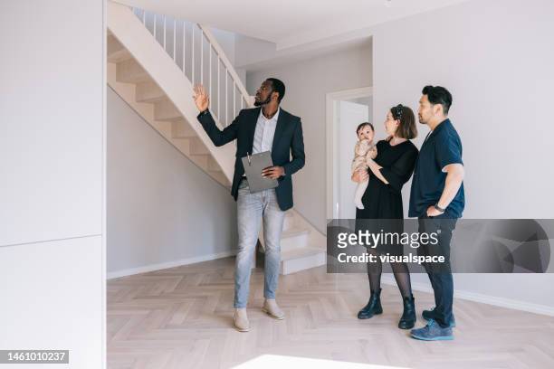 real estate agent giving home tour for potential clients. - real people family portraits stockfoto's en -beelden
