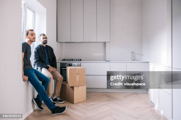 couple taking a break from moving - gay couple new house stock pictures, royalty-free photos & images