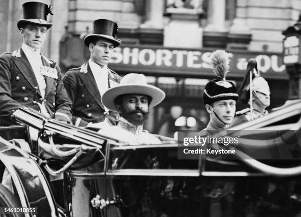 Abyssinian Emperor Haile Selassie sits in an open carriage with the Duke Of York during his visit to London, 1924. Two uniformed footmen sit behind...