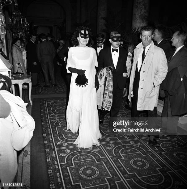 Couple in masks arriving at Truman Capote's Black and White Ball in the Grand Ballroom at the Plaza Hotel in New York City