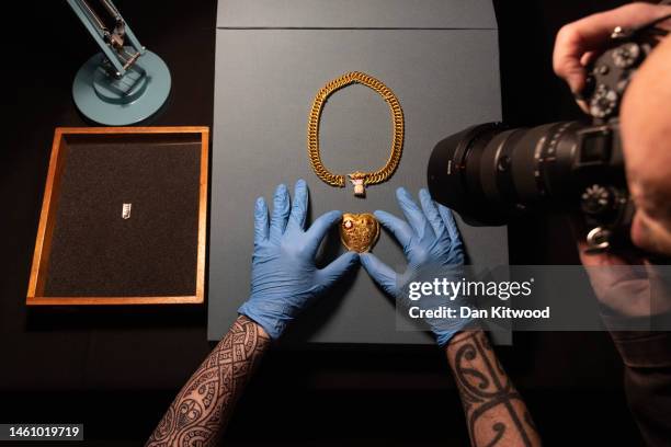 Two items, a gold pendant and a silver strap-end are displayed during a photocall at The British Museum on January 31, 2023 in London, England. The...