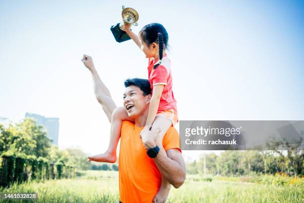 father and daughter celebrating with trophy in hands - receiving trophy stock pictures, royalty-free photos & images