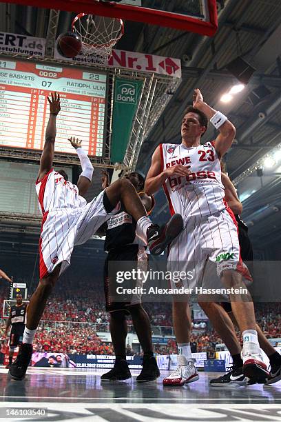 Marcus Slaughter of Bamberg and his team mate Casey Jacobsen shoot against Kelvin Torbet of Ulm during game 3 of the Beko BBL finals between Brose...