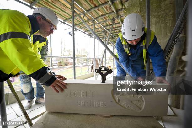 Stonemasons fix the Secret Spitfire commemorative stone into place at Salisbury Cathedral on January 31, 2023 in Salisbury, England. Eighty-three...