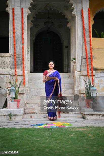 indian woman in a sari standing with a plate full of rangoli colors - preparation of gudi padwa festival stock pictures, royalty-free photos & images