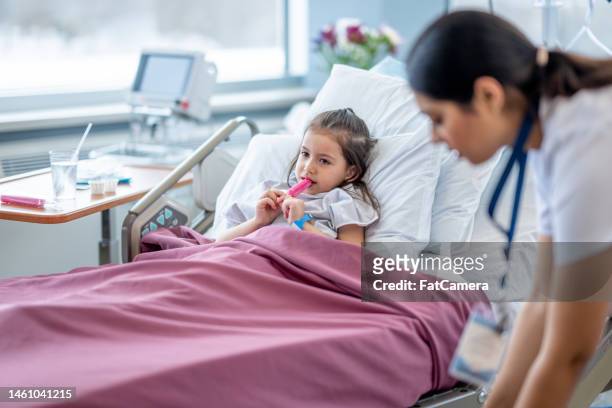 nurse checking on a young patient - nurse maroon stock pictures, royalty-free photos & images